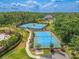 Aerial view of well-maintained tennis courts surrounded by lush landscaping in a gated community at 20404 Autumn Fern Ave, Tampa, FL 33647
