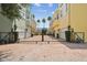 Gated townhome community showcasing colorful facades, brick driveway, and mature landscaping at 2305 Victoria Gardens Ln, Tampa, FL 33609