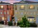 Charming townhomes showcasing colorful facades and a tile roof against a beautiful sunset sky at 2305 Victoria Gardens Ln, Tampa, FL 33609