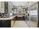 Modern kitchen featuring stainless steel appliances, custom backsplash, and gray tile flooring at 2305 Victoria Gardens Ln, Tampa, FL 33609