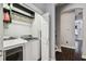 Functional laundry area featuring modern appliances, built-in shelves, and dark wood flooring at 2305 Victoria Gardens Ln, Tampa, FL 33609
