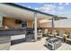 Relaxing covered deck with outdoor kitchen, comfortable seating, and a cozy fire pit at 2305 Victoria Gardens Ln, Tampa, FL 33609