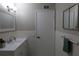 This bathroom features tiled walls, a white vanity, modern lighting, and a mirrored medicine cabinet at 2360 World Parkway Blvd # 36, Clearwater, FL 33763