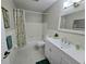 Bright bathroom featuring a shower-tub, white vanity with a sink, neutral paint, and decorative floral shower curtain at 2360 World Parkway Blvd # 36, Clearwater, FL 33763