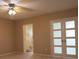 Neutral bedroom with a ceiling fan, light wood floors, and a view of the bathroom at 2360 World Parkway Blvd # 36, Clearwater, FL 33763