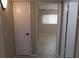 Hallway with neutral walls offers easy access to a room with a window and white blinds at 2360 World Parkway Blvd # 36, Clearwater, FL 33763