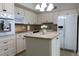 Charming kitchen featuring white cabinets, modern appliances, a functional island, and neutral countertops at 2360 World Parkway Blvd # 36, Clearwater, FL 33763