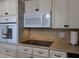 Well-lit kitchen showcases stainless steel appliances, white cabinets with dark hardware, and warm toned backsplash at 2360 World Parkway Blvd # 36, Clearwater, FL 33763