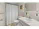 Functional bathroom featuring a shower with curtain, tile walls, and sink with a mirror; compact and well-maintained at 2426 Persian Dr # 52, Clearwater, FL 33763