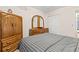 This bedroom has wood floors, a striped bedspread and matching wooden dresser and wardrobe at 2426 Persian Dr # 52, Clearwater, FL 33763