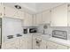 Efficient kitchen with white cabinetry and appliances, complemented by updated fixtures and ample counter space at 2426 Persian Dr # 52, Clearwater, FL 33763