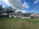 A house's backyard with a grass lawn, a screened patio, and a white back door visible on the tan house at 2507 Hollis Dr, Tampa, FL 33618