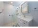 All-white bathroom showcasing a walk-in shower with glass door and vanity with silver trimmed mirror at 2880 81St N St, St Petersburg, FL 33710