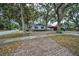 Brick driveway and mature trees create a welcoming entrance, enhancing the home's curb appeal at 2880 81St N St, St Petersburg, FL 33710