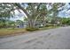 Well-maintained home showcasing mature trees, manicured landscaping, and a welcoming deck area for outdoor enjoyment at 2880 81St N St, St Petersburg, FL 33710