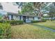 Charming single story home with manicured landscaping, green shutters and welcoming entrance at 2880 81St N St, St Petersburg, FL 33710