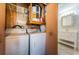 Laundry area with washer, dryer, shelving and next to renovated bathroom at 2880 81St N St, St Petersburg, FL 33710