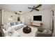 Bright living room with ceiling fan, plush seating, and natural light streaming through shuttered windows at 2880 81St N St, St Petersburg, FL 33710