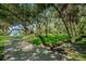 Scenic view of a park with mature trees, lush greenery, and a glimpse of a lakeside bench at 2880 81St N St, St Petersburg, FL 33710
