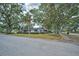 Exterior street view of a well-kept home with mature trees and a charming, inviting curb appeal at 2880 81St N St, St Petersburg, FL 33710
