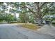 Street view of home with lush trees, and a carport, offering a glimpse of suburban living at 2880 81St N St, St Petersburg, FL 33710