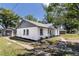 Charming single-story home with a tidy lawn and flowerbeds in front of the windows at 308 E 121St Ave, Tampa, FL 33612