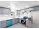 Bright kitchen featuring stainless steel appliances, modern cabinetry, and stylish white marble backsplash at 308 E 121St Ave, Tampa, FL 33612