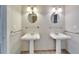 Bright bathroom featuring double pedestal sinks with round mirrors and modern lighting fixtures at 308 S Bungalow Park Ave # B, Tampa, FL 33609