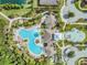 Aerial photo of a community pool and splash pad with various water features amidst lush tropical foliage at 32713 Brooks Hawk Ln, Wesley Chapel, FL 33543