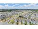 Bird's-eye view of a well-organized neighborhood featuring modern homes, sidewalks, and common green spaces under a blue sky at 32713 Brooks Hawk Ln, Wesley Chapel, FL 33543