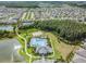 Aerial view of a community pool, sand volleyball court, and surrounding greenery, highlighting recreational amenities at 32713 Brooks Hawk Ln, Wesley Chapel, FL 33543