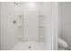 White shower featuring built-in shower shelves and a clear glass door at 32713 Brooks Hawk Ln, Wesley Chapel, FL 33543