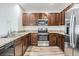 Contemporary kitchen boasts stainless steel appliances, granite countertops, and stylish dark cabinets at 32713 Brooks Hawk Ln, Wesley Chapel, FL 33543