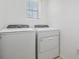 Bright laundry room featuring a modern washer and dryer, offering convenience and efficiency at 32713 Brooks Hawk Ln, Wesley Chapel, FL 33543