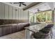 Covered outdoor kitchen featuring a countertop bar, mosaic tile backsplash, sink, and seating at 32713 Brooks Hawk Ln, Wesley Chapel, FL 33543