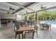 Spacious covered patio area with tables and chairs near the community pool and lush greenery at 32713 Brooks Hawk Ln, Wesley Chapel, FL 33543