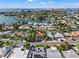 Wide aerial view showcasing a waterfront community and a charming home with lush greenery at 3555 Belle Vista E Dr, St Pete Beach, FL 33706