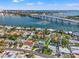 Aerial view showcasing the home and the beautiful bay with nearby bridge at 3555 Belle Vista E Dr, St Pete Beach, FL 33706