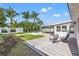 Spacious backyard with a deck, mature palms, and lush lawn is perfect for relaxation and outdoor entertaining at 3555 Belle Vista E Dr, St Pete Beach, FL 33706