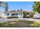 Charming single-story home boasts a classic style with well-maintained landscaping, a circular driveway, and a tiled roof at 3555 Belle Vista E Dr, St Pete Beach, FL 33706