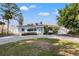 Charming single-story home with a circular driveway, well-manicured landscaping, and a light-colored facade at 3555 Belle Vista E Dr, St Pete Beach, FL 33706