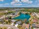 Scenic aerial view of community homes encircling a sparkling lake with fountain feature at 3558 65Th Avenue E Cir, Sarasota, FL 34243