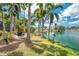 Serene backyard with lake views, including a seating area and birdhouse for nature enthusiasts at 3558 65Th Avenue E Cir, Sarasota, FL 34243