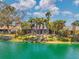 Home's backyard offers scenic lake views framed by tall palm trees, creating a tranquil outdoor living space at 3558 65Th Avenue E Cir, Sarasota, FL 34243