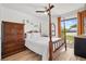 Bright bedroom with a four-poster bed, ceiling fan, and a view to the backyard at 3558 65Th Avenue E Cir, Sarasota, FL 34243