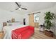 Cozy bedroom featuring a seating area, ceiling fan, and laminate wood flooring at 3558 65Th Avenue E Cir, Sarasota, FL 34243