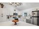 Bright kitchen boasts white cabinetry, stainless steel appliances, quartz counters and modern pendant lighting at 3558 65Th Avenue E Cir, Sarasota, FL 34243