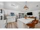 A well-lit kitchen featuring white cabinets, stainless steel appliances, and a stone countertop island at 3558 65Th Avenue E Cir, Sarasota, FL 34243