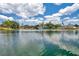 Scenic lake view with a fountain, mature trees, and blue skies at 3558 65Th Avenue E Cir, Sarasota, FL 34243