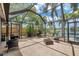 Enclosed lanai featuring ample seating options with scenic views of the surrounding greenery and lake at 3558 65Th Avenue E Cir, Sarasota, FL 34243